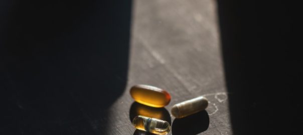 brown and black medicine tablets on black surface